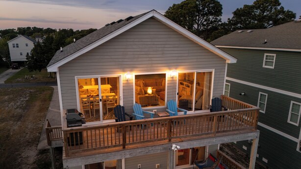 Uma casa de dois andares com varanda, deck e garagem.