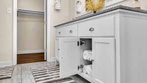 A bathroom with a white vanity, a mirror, and a towel rack.