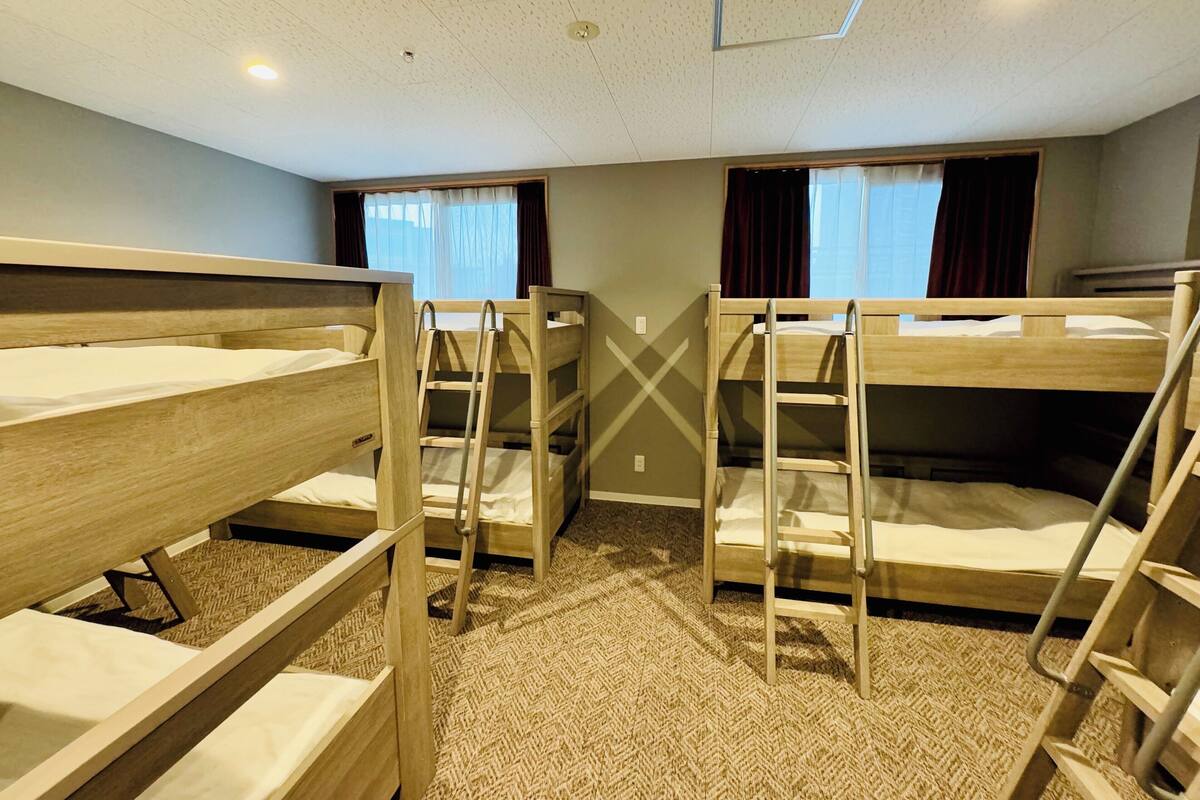 A room with bunk beds, a carpeted floor, and a ceiling with recessed lighting.
