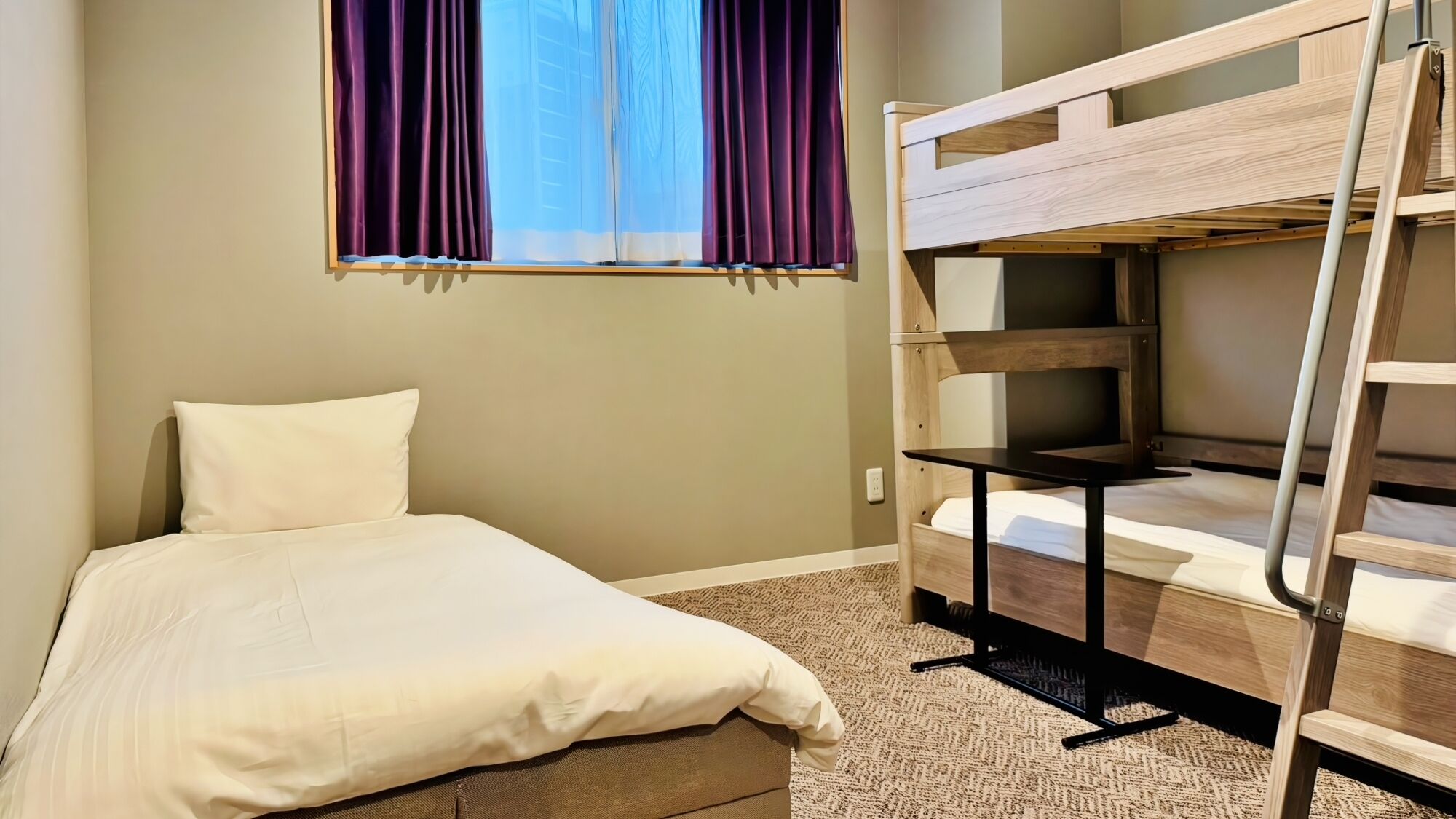 Un lit superposé avec un bureau, un lit simple et une fenêtre avec des rideaux.