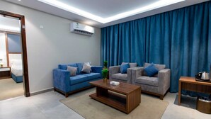 Una sala moderna con un sofá azul, una mesa de centro de madera y un telón de fondo azul.