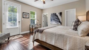 A bedroom with a bed, a ceiling fan, a desk, and a chair. - The Midtown Haven, Pets Welcome! (Tallahassee)