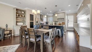 A modern kitchen with a central island, built-in shelves, and pendant lighting. - The Midtown Haven, Pets Welcome! (Tallahassee)