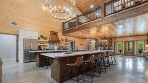 A spacious kitchen with a central island, bar stools, and a mezzanine level.