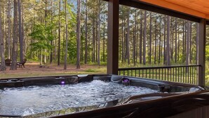 A hot tub with a view of a forest.