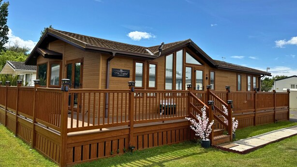 Un bâtiment en bois avec une enseigne indiquant « New England » et une terrasse dotée de balustrades.