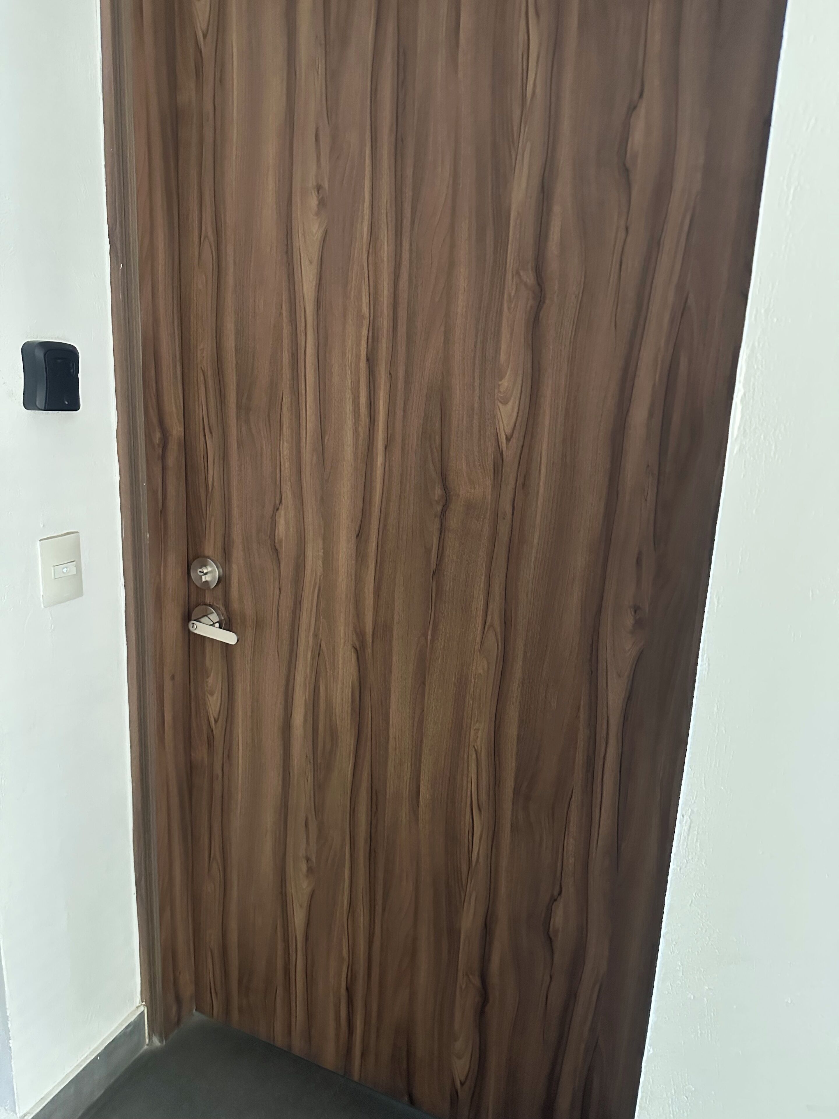 A wooden door with a keyhole and a handle.