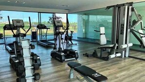 Un gimnasio con cintas de correr, elípticas y pesas sueltas.