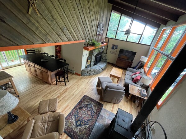 Amplia sala de estar con cocina, comedor y chimenea.