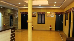 A lobby with a reception desk, a staircase, and a large pillar.