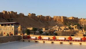 A rooftop terrace with a view of a fortified cityscape.