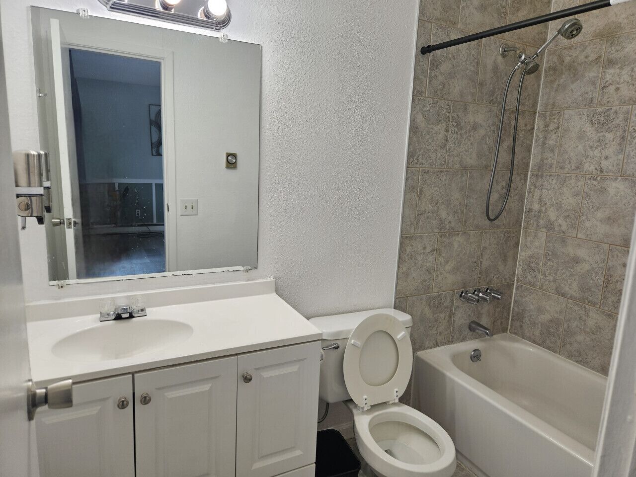 Un baño con lavamanos, inodoro y bañera blancos.