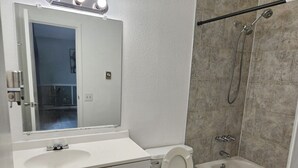 A bathroom with a white sink, toilet, and bathtub. - Apartment Close to Hospital and UAA (Anchorage)