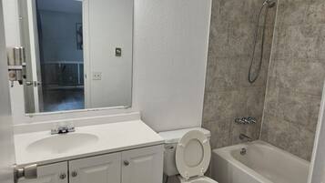 Un baño con lavamanos, inodoro y bañera blancos.