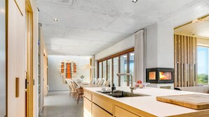 Een moderne keuken met een groot kookeiland, een inbouwfornuis en uitzicht op de omgeving.