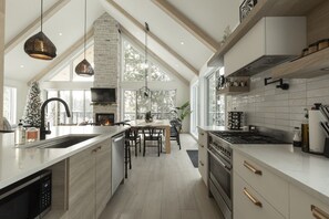 A modern kitchen with a large island, built-in appliances, and a fireplace.