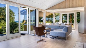A modern living room with a sofa, armchair, and dining area. - "Ephra" - 150m from the sea by Interhome (Bjert)