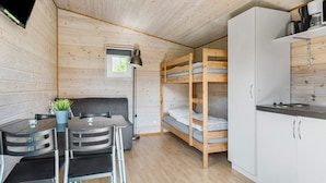 A compact room with a bunk bed, a small kitchenette, a dining area with a table and chairs, and a single window providing natural light. - 4 Person Holiday Park Home in Malling (Malling)