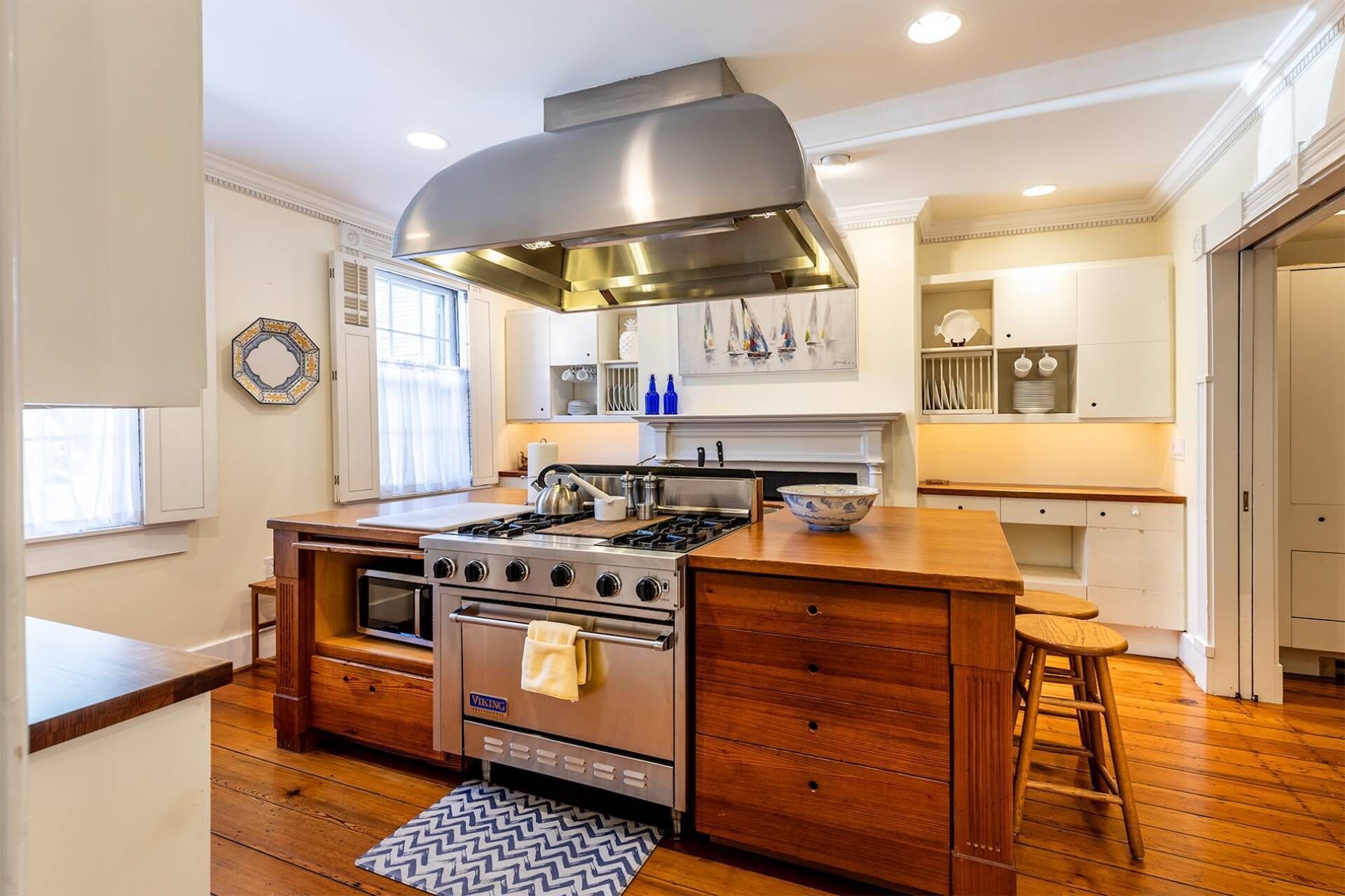 A modern kitchen with a central island, a stove, and ample storage cabinets.
