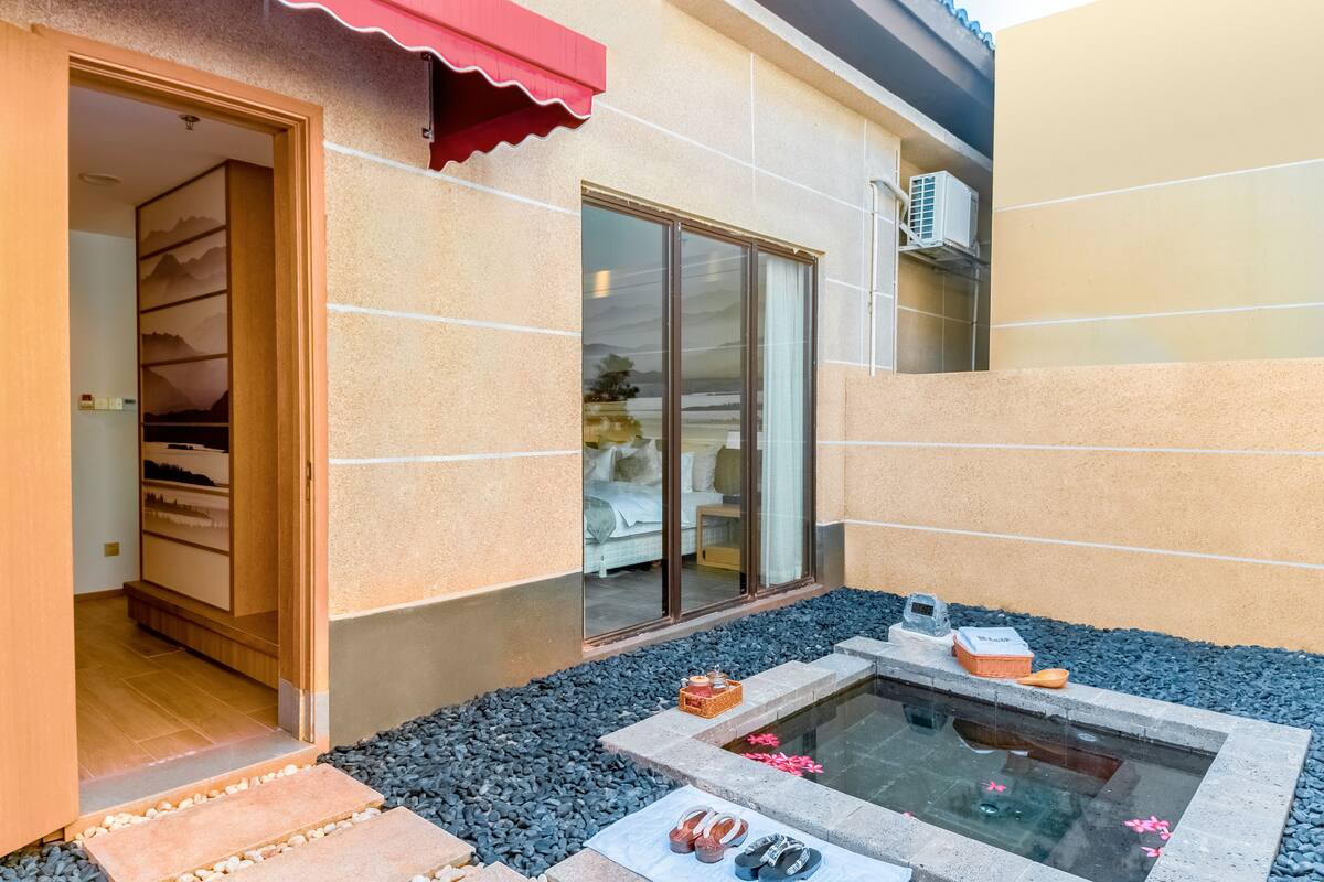 A spa area with a hot tub, a wooden door, and a view of the room inside.