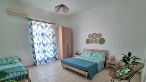 A bedroom with a bed, a chair, a wardrobe, a bedside table, and a wall decoration.