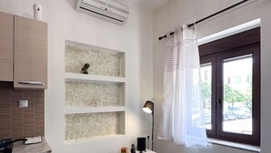 Eine moderne Küche mit eingebautem Backofen, einem kleinen Schrank und einem Fenster mit Vorhängen.