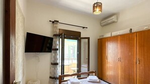 Ein Schlafzimmer mit Bett, Kleiderschrank, Fernseher und Fenster.