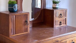 Eine Holzkommode mit Spiegel, zwei Schubladen und zwei kleinen Schränken.