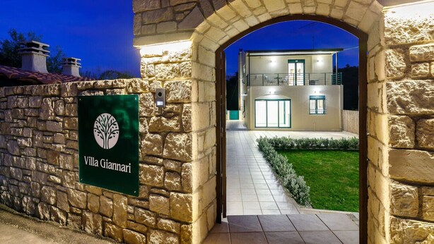 A stone archway leading to a villa with a sign reading "Villa Giannari". - Villa Giannari | Stalos (Chania)