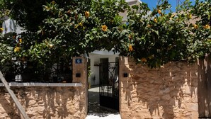 Un mur de pierre avec une porte, un panneau portant le chiffre « 6 », et un bâtiment en arrière-plan.