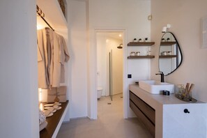 Ein modernes Badezimmer mit einem weißen Waschbecken, einem Spiegel und einem Handtuchhalter.