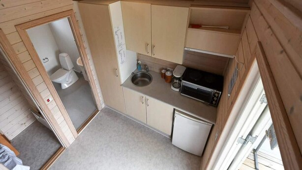 A compact kitchen with a sink, stove, and white cabinets. - 6 Person Holiday Park Home in Asperup (Middelfart)