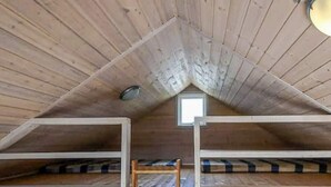 A small attic room with sloped wooden ceilings, a skylight, and a single wooden ladder. - 6 Person Holiday Park Home in Asperup (Middelfart)