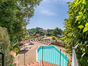 Area piscina con lettini e vista su una città sullo sfondo.