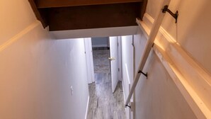 A narrow stairway with wooden steps leading to a landing.
