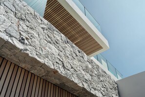 A modern building with a stone facade, wooden slats, and a glass balcony. - The View (Gerringong)