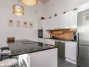 Een koelkast, een magnetron, een vaatwasser, kookgerei, borden en bestek