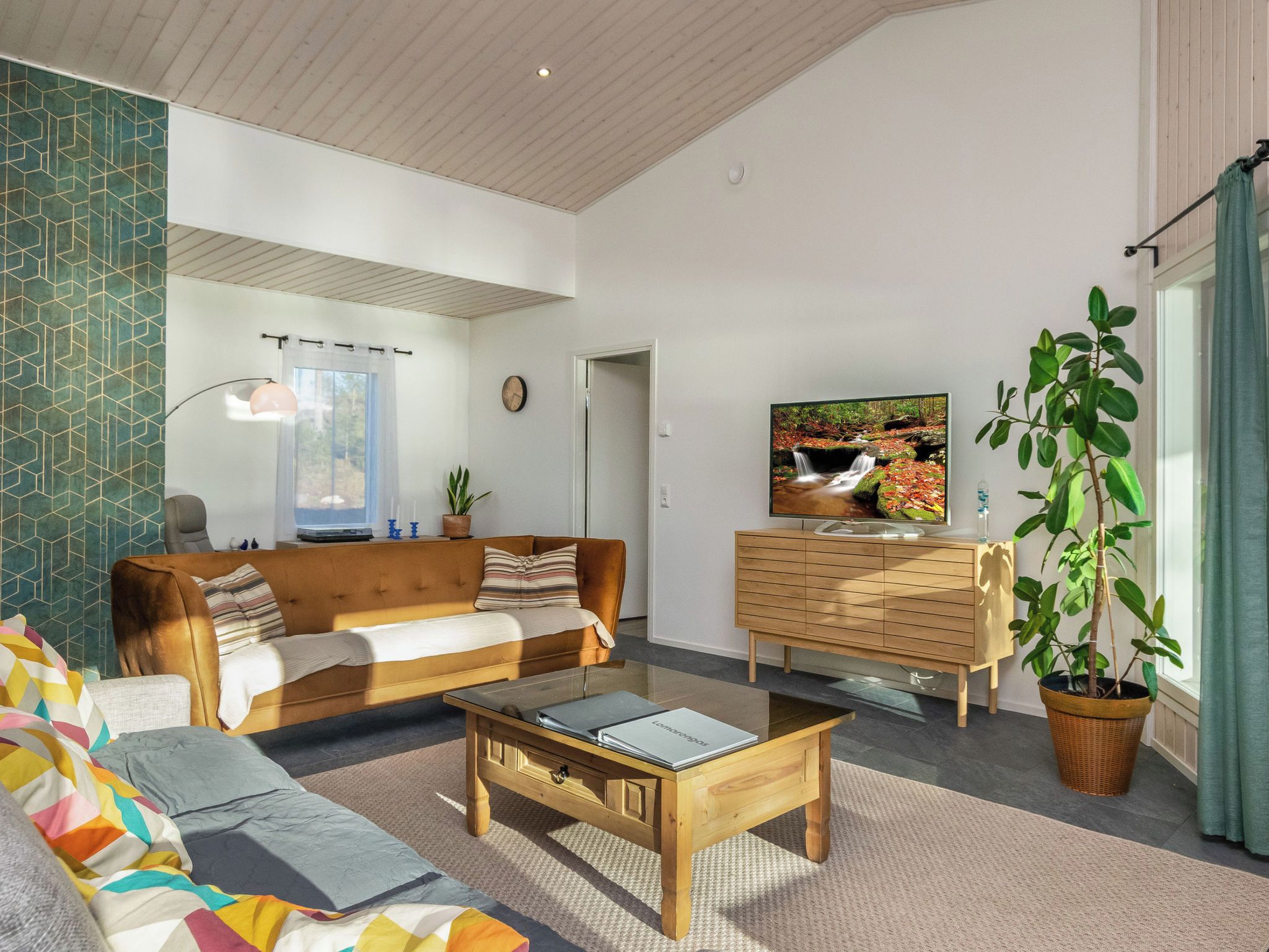 Een woonkamer met een bank, salontafel en een televisie op een houten kast.