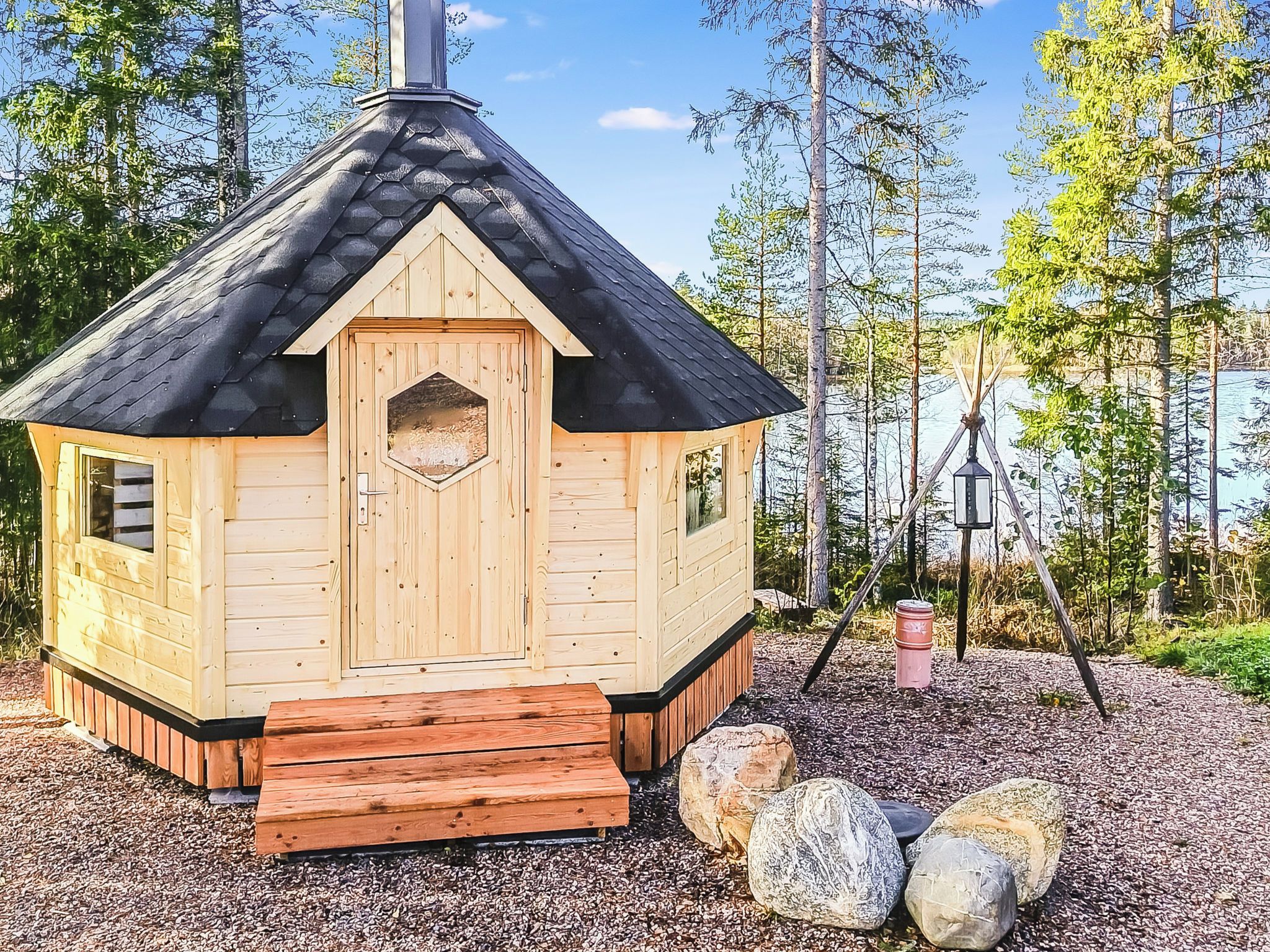 Une petite cabane en bois avec un toit à deux versants, une porte d’entrée et une fenêtre.