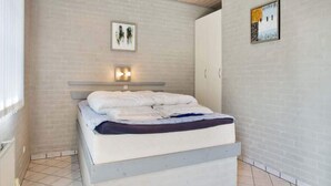 A bedroom with a bed, a wall-mounted shelf, and two framed pictures. - 2 Person Holiday Park Home in Graested (Graested)