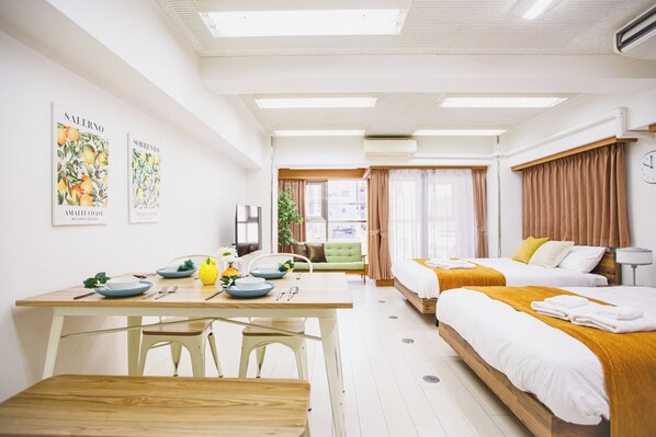 A hotel room with a dining area, two beds, a sofa, and a large window. - R Residence Tanimachi (Osaka)