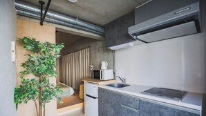 Une cuisine compacte équipée d’un four à micro-ondes encastré, d’un évier et d’un petit réfrigérateur.