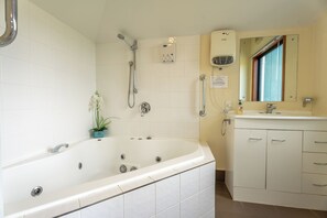 Een douche, een bubbelbad, handdoeken, zeep
