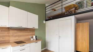 A modern kitchen with white cabinets, a wooden countertop, and a black-framed window. - Dify Lucky - 10 Min Centre de Lyon (Villeurbanne)