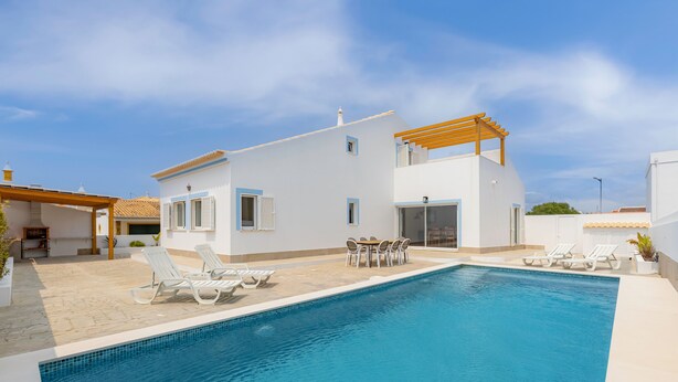Eine moderne Villa mit Swimmingpool, Sitzgelegenheit im Freien und einer Pergola.