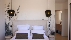 A bedroom with a large bed, two bedside tables, a nightstand, and a wall-mounted light fixture. - Luxury apartment for 6 people, sea view, 800m from center and beaches (L'Île-Rousse)