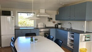 A compact kitchen with a dining area, a refrigerator, a stove, and a sink.