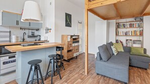 Een moderne keuken met een centraal eiland, barkrukken en een eethoek.