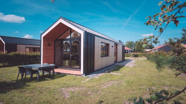 A modern, single-story house with a large glass door and a small porch. - Spacious Nature Retreat (Bant)