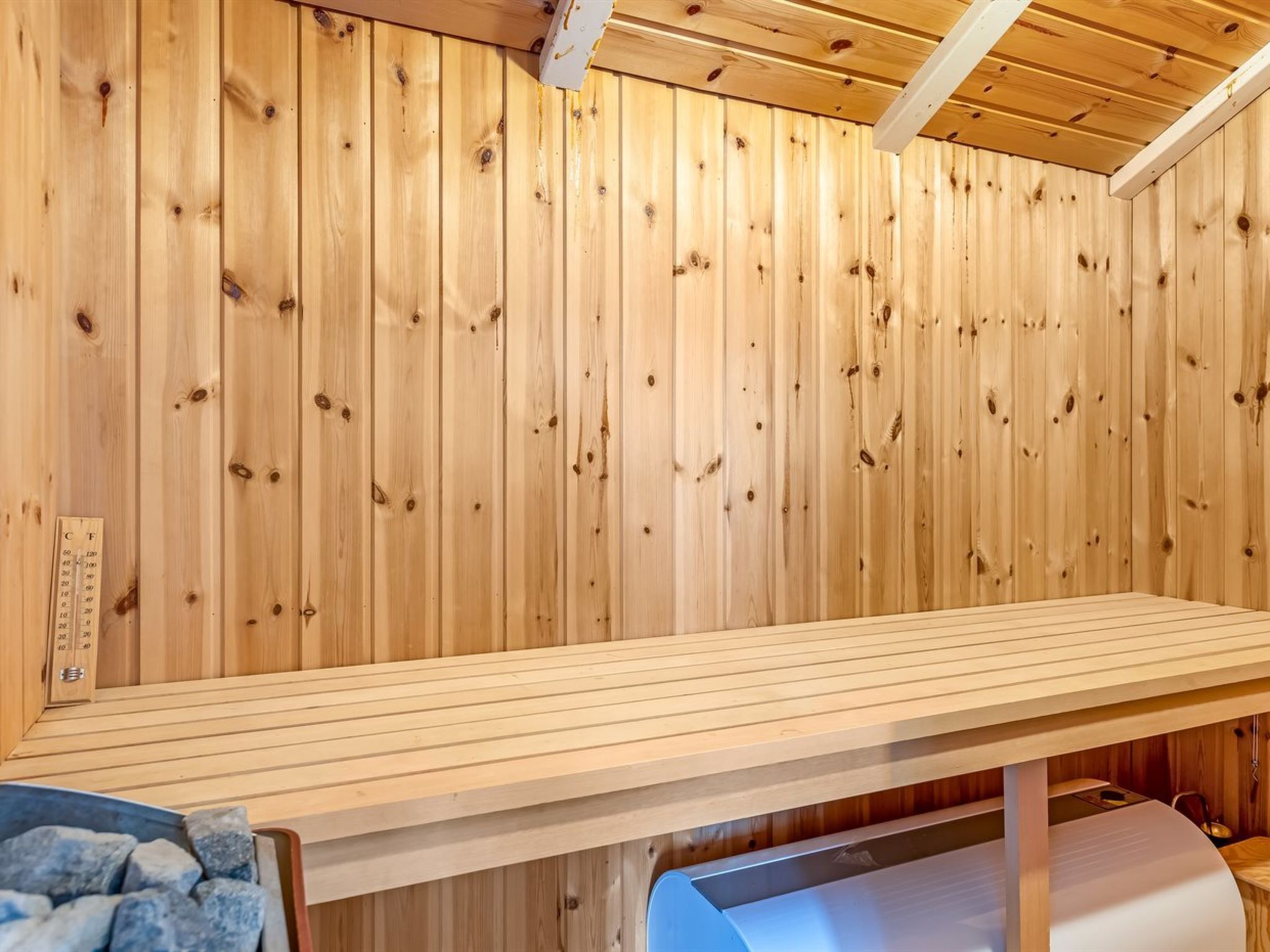 A sauna room with wooden walls and a bench.